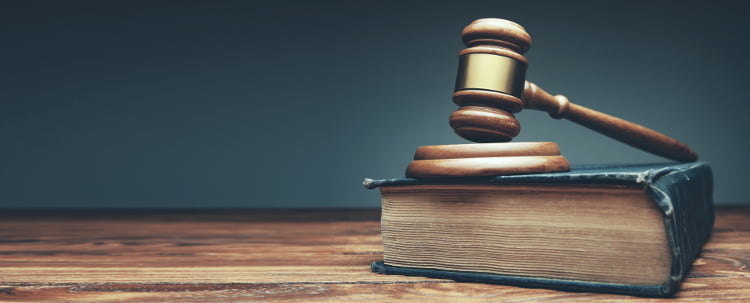 Ustawa o grach hazardowych to podstawowy akt prawny, w którym znajdują się regulacje dotyczące zakładów bukmacherskich i innych gier hazardowych w Polsce Młotek sędziego leżący na kodeksie