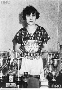 Stanisława Walasiewicz z nagrodami które zdobyła podczas swego pobytu w USA. Na koszulce ma poprzypinane medale. Stanisława Walasiewicz z nagrodami