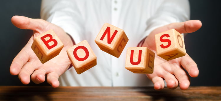 Mężczyzna prezentuje kości ułożone w słowo "bonus".